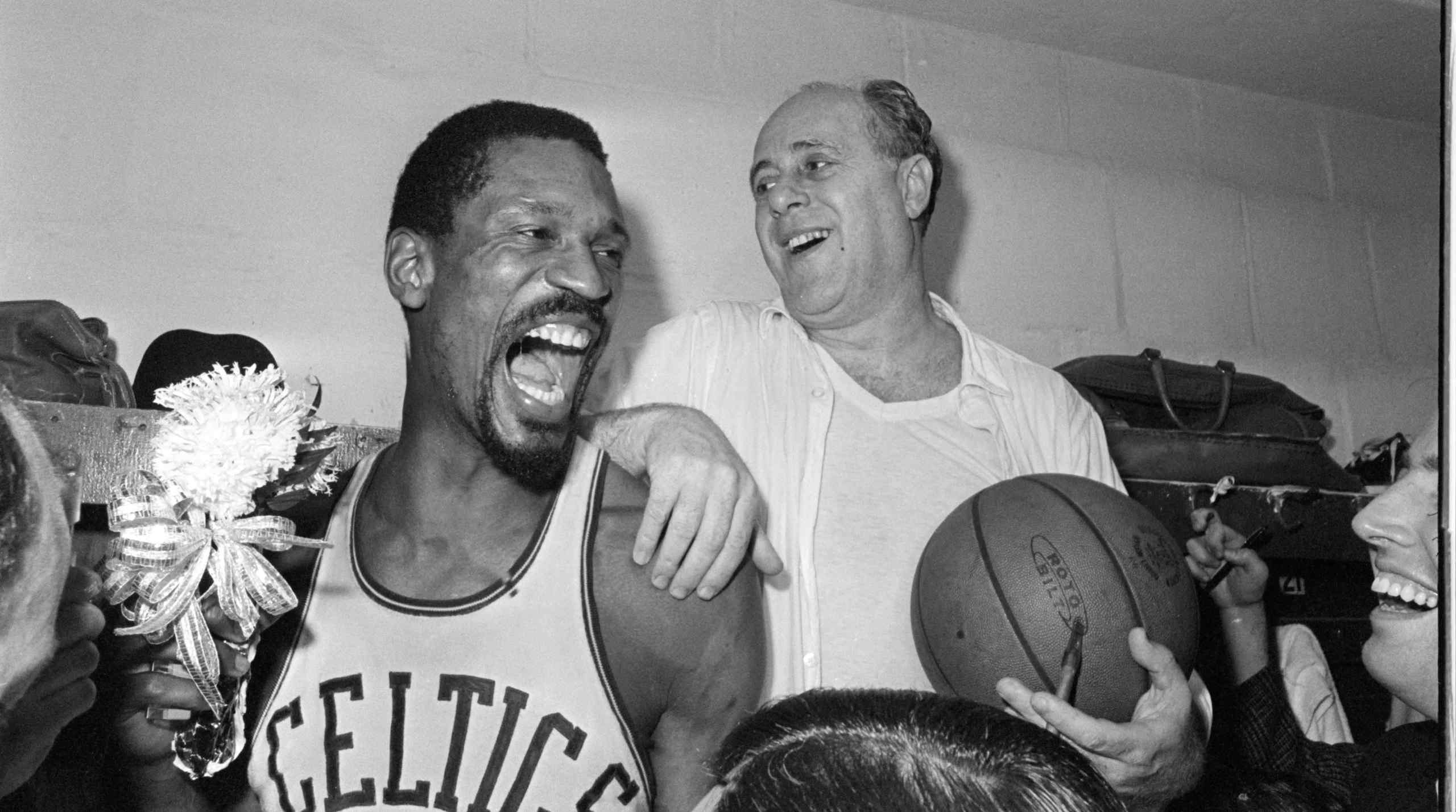 Boston Celtics star Bill Russell celebrates in the locker room with coach Red Auerbach